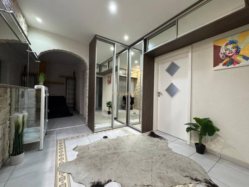 Interiér 3-pokojového bytu s dlažbou, zrcadlovou skříní a dekorativními rostlinami.