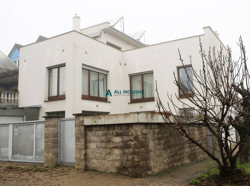 Rodinný dům na Súľovské ulici, Bratislava - Ružinov s příjezdovou cestou a plotem z cihel.