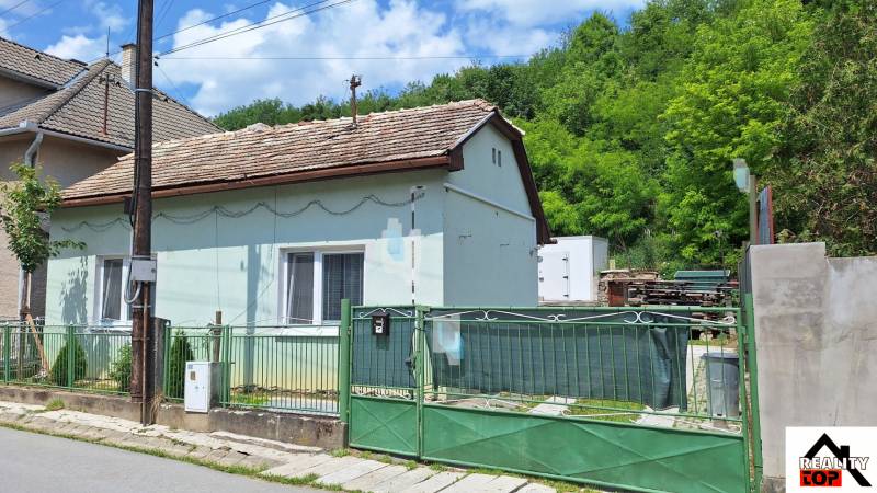 Rodinný dům v Hajnáčce s jednopodlažním designem, krytý střechou a zeleným plotem.