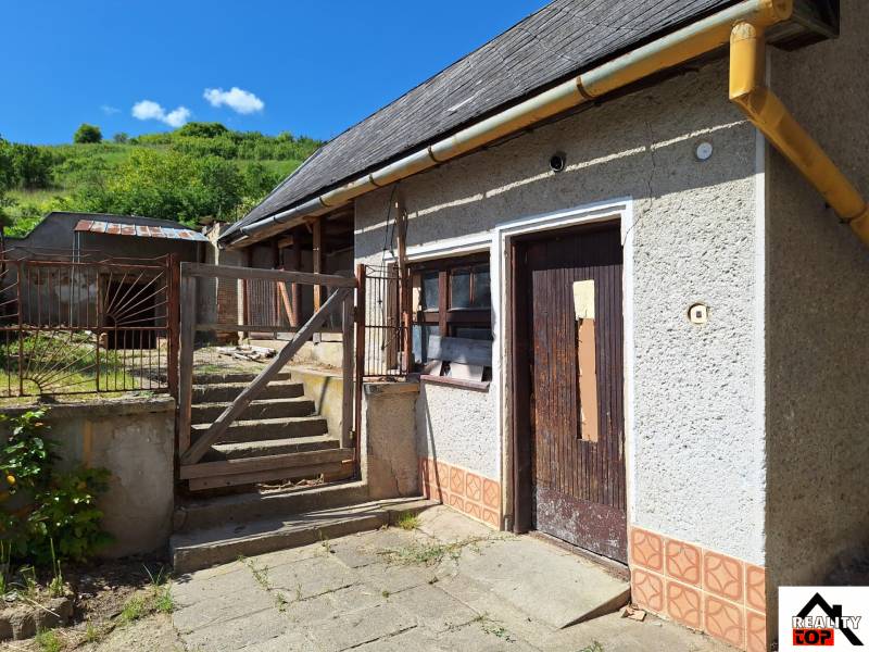 Rodinný dům v Šíde se starým dvorem, schodištěm a zanedbanými detaily exteriéru.