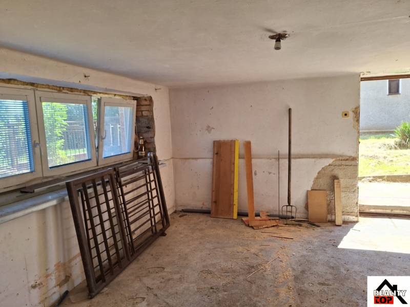 Interiér rodinného domu s nářadím a stavebním materiálem.