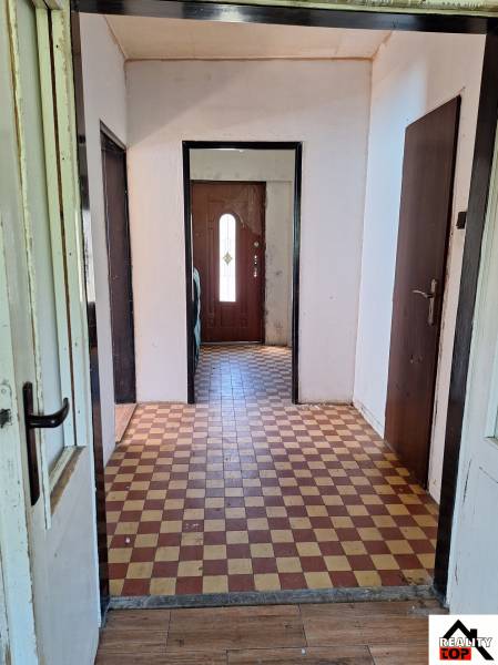 Chodba v rodinném domě s dlažbou a dveřmi.