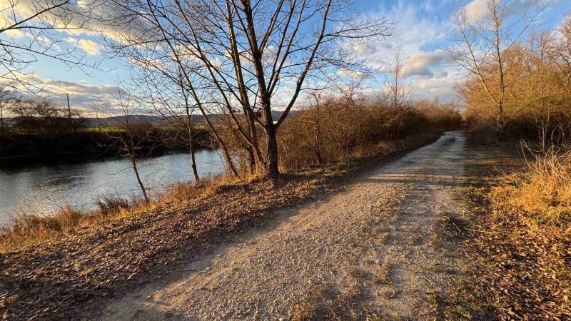 Rekreační pozemky v Nová Ves nad Váhom s přírodní cestou a řekou na podzim.