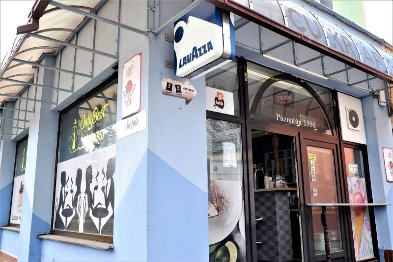 Exteriér obchodních prostor v Šali s kavárenskými motivy na výloze.