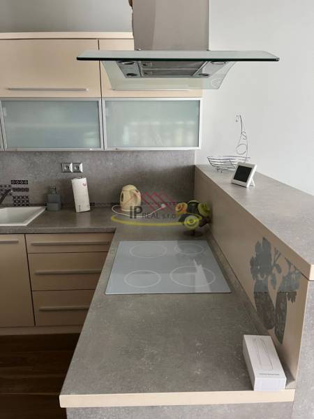 Kuchyňská linka ve 4-pokojovém bytě s indukční varnou deskou a digestoří.