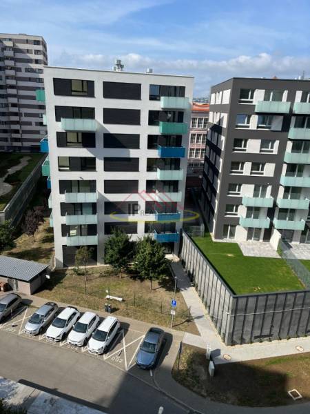 Pohled na moderní bytové domy se zaparkovanými auty na ulici Jégého, Bratislava - Nivy.