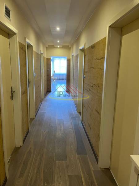 Chodba se vstupy do místností ve 4pokojovém bytě, podlaha s dřevěným dekorem.