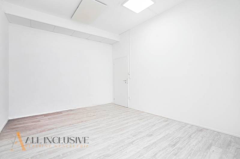 Interiér s bílými stěnami a podlahou s dřevěným dekorem v kanceláři.