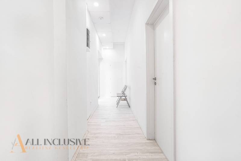 Světlá chodba s dřevěnou podlahou a židlí v kanceláři.