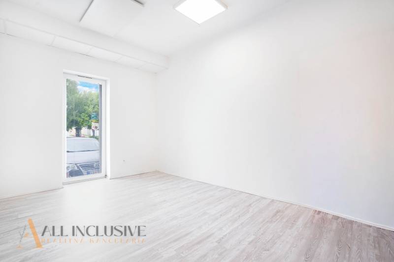 Prázdná kancelář s podlahou s dřevěným dekorem a velkým oknem.