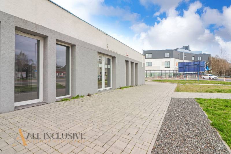 Na ulici Vajanského, vedle obchodní prostory s moderní architekturou a zpevněnými chodníky.