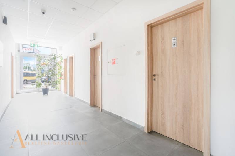 Chodba v kancelářích na Vajanského ulici v Galantě s dřevěnými dveřmi a rostlinou.