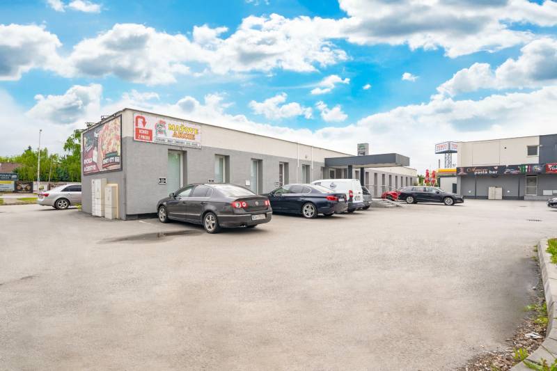 Budovy na Clementisových Sadech v Galantě s zaparkovanými vozidly u kanceláří.