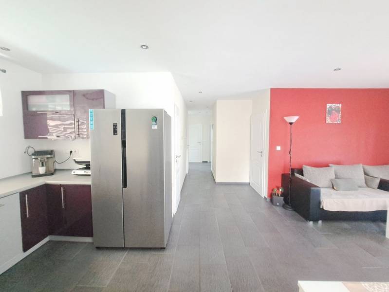 Kuchyně s fialovými skříňkami a šedou podlahou v rodinném domě.