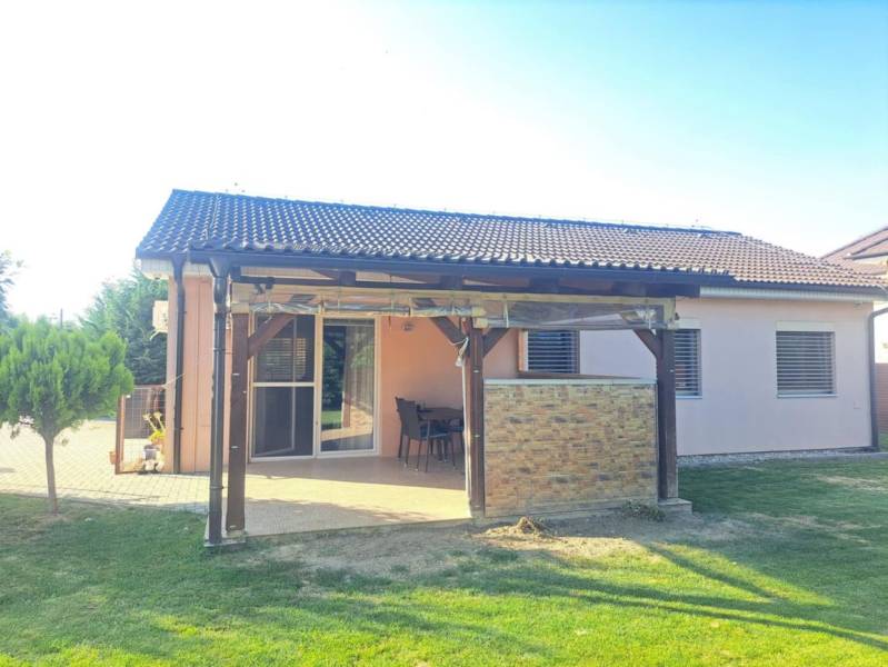 Rodinný dům v Čiernom Brodě s terasou, zahradou a pergolou, obklopený zeleným trávníkem.