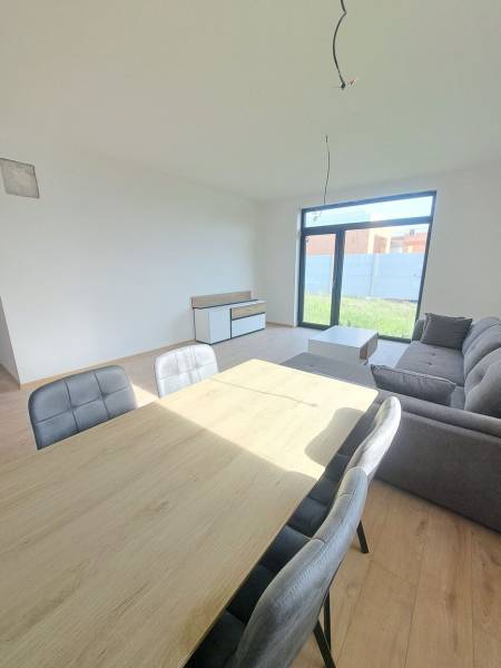 Jídelna v rodinném domě s pohovkou a podlahou s dřevěným dekorem.