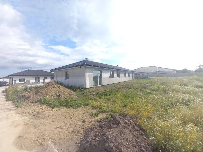 Stavba rodinného domu v Galantě obklopená přilehlým pozemkem a dalšími domy.