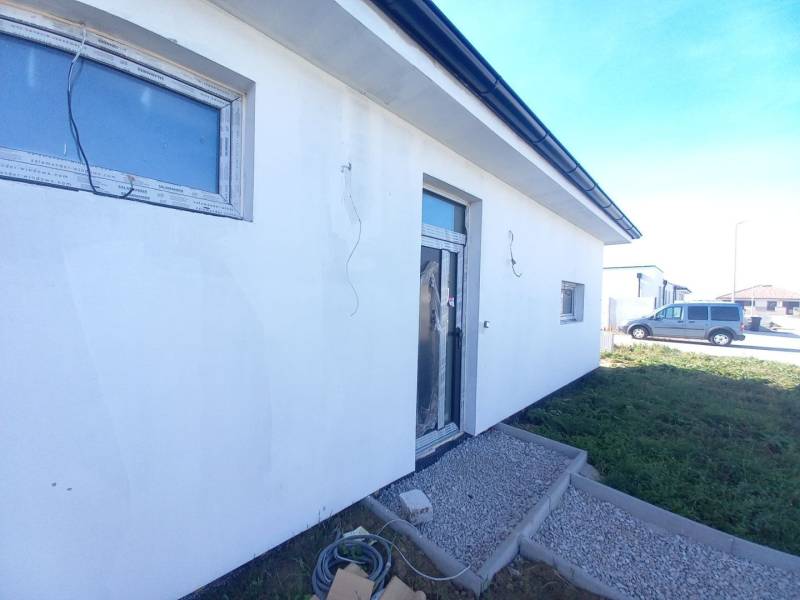 Rodinný dům v Galantě, s bílou fasádou a zámkovou dlažbou na předzahrádce.