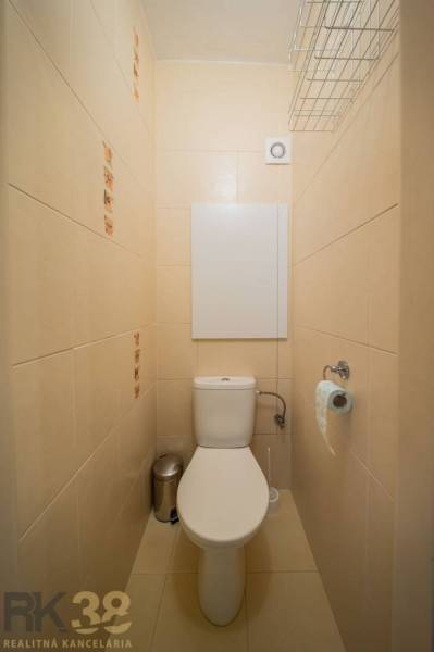 Toaleta s béžovými obklady v 2-pokojovém bytě.