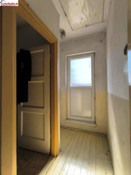 Chodba v rodinném domě se světlým vstupem a dřevěnou podlahou.