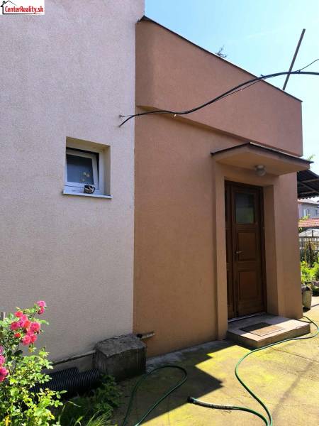 Rodinný dům v Partizánském s barevnou omítkou a zahradou.