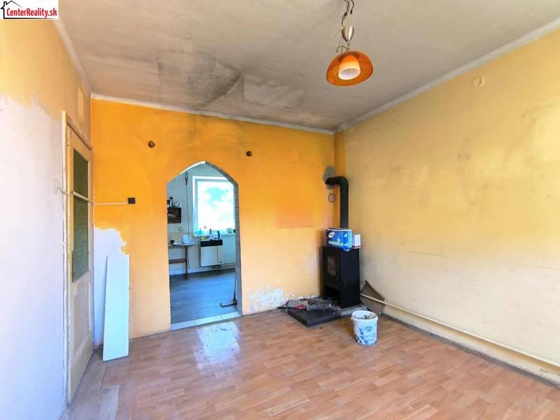 Pokoj v rodinném domě s kamny s dveřmi do kuchyně.