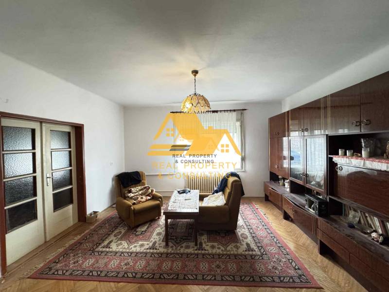 Obývací pokoj v rodinném domě s podlahou s dřevěným dekorem a bohatým nábytkem.