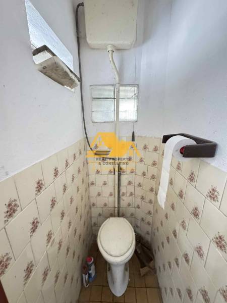 Koupelna se staršími dlaždičkami v rodinném domě.