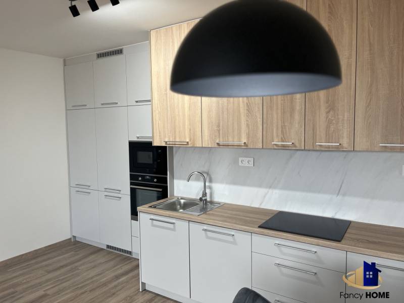 Kuchyně v 2-pokojovém bytě s podlahou s dřevěným dekorem a světlým nábytkem.