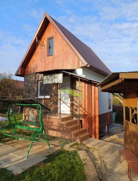 Chata v Pozdišovcích s dřevěným obkladem a houpačkou na zahradě.