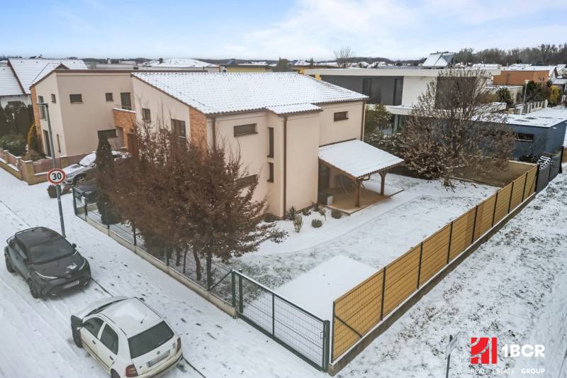 Rodinný dům v Bratislavě - Čunově na ulici Konopiská, zasněžená ulice, auta zaparkovaná.