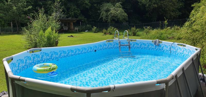 Nafukovací bazén na zahradě chaty, obklopený zelení na Hviezdoslavově ulici v Tisovci.