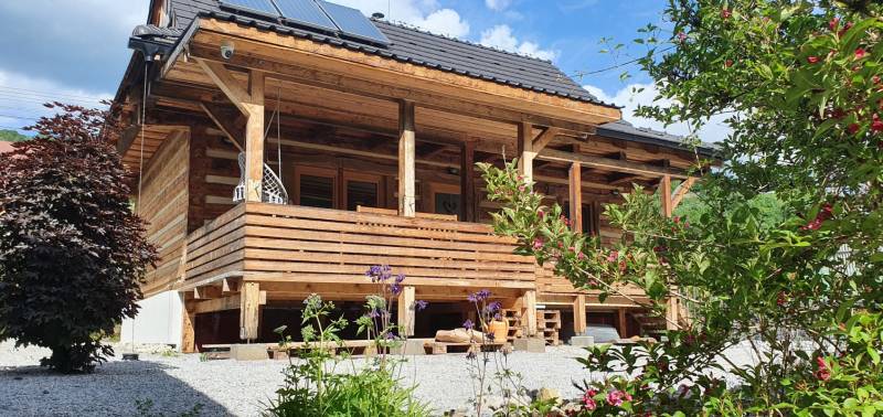 Dřevěná chata na Hviezdoslavově ulici v Tisovci s dřevěnou terasou a zahradou.