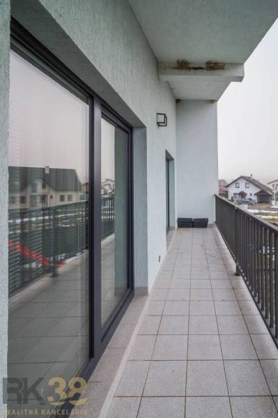 Balkon rodinného domu na Krátké ulici ve Spišském Bystrom s dlažbou a skleněným zábradlím.