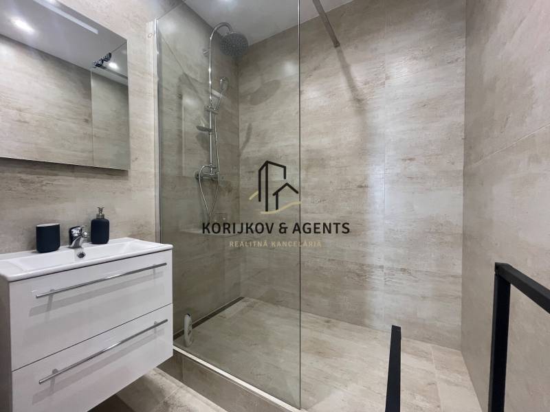 Koupelna ve 3pokojovém bytě se sprchovým koutem a úložným prostorem pod umyvadlem.