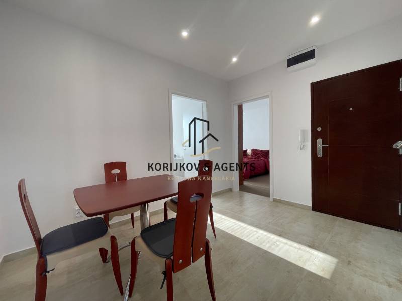 Jídelní stůl a židle v předsíni 3-pokojového bytu s dlažbou.