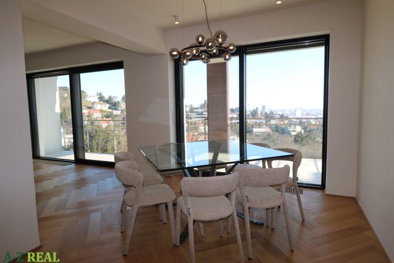 Jídelna ve 4-pokojovém bytě se skleněnou stěnou a podlahou s dřevěným dekorem.