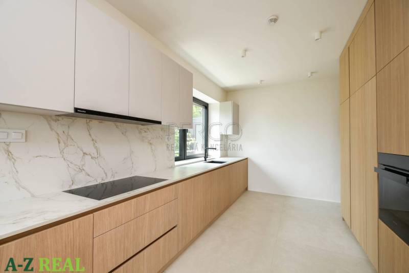 Kuchyně ve 4-pokojovém bytě s bílými skříňkami, mramorovým povrchem a dřevěným dekorem.