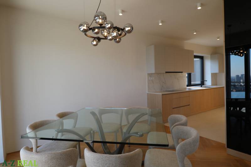 Jídelna se skleněným stolem a židlemi, 4pokojový byt, podlaha s dřevěným dekorem.