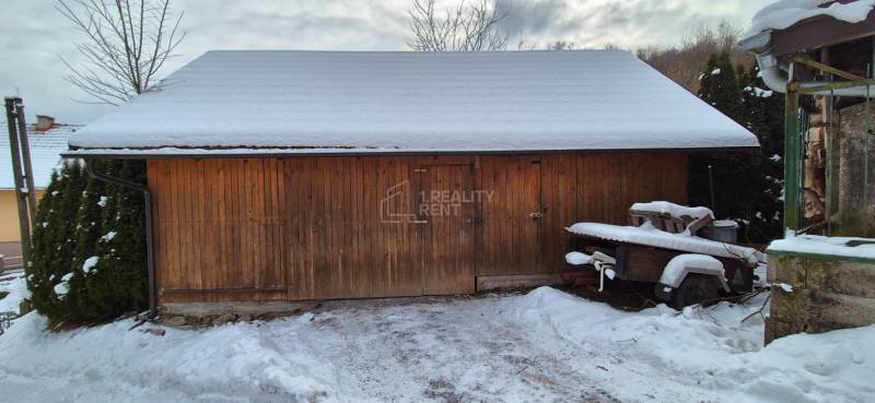 Na fotografii z Ochodnice je dřevěný skladný přístřešek u rodinného domu se sněhovou pokrývkou.
