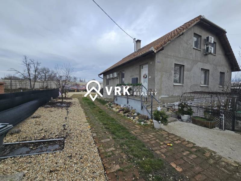 Rodinný dům v Hernádkaku se zahradou, štěrkovou příjezdovou cestou a dřevěnými prvky.