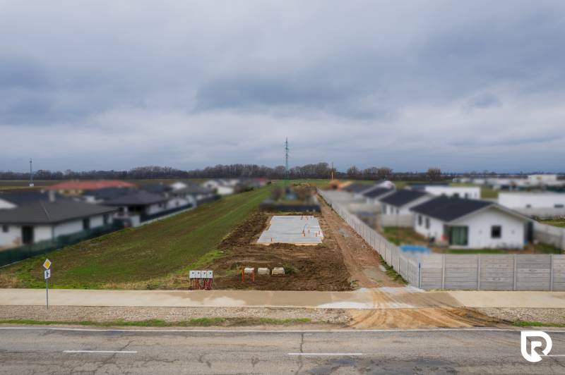 Základy budoucího rodinného domu v Sokolovcích mezi sousedními obydlími a cestou.