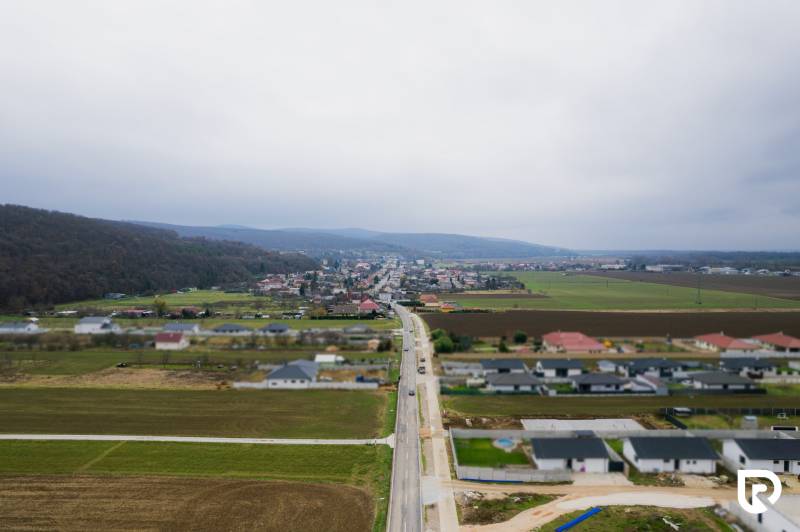Letecký pohled na vesnici Sokolovce s rodinnými domy a rozlehlými poli.