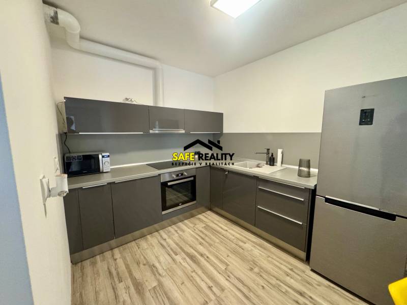 Kuchyně v 2-pokojovém bytě s podlahou s dřevěným dekorem a šedou linkou.