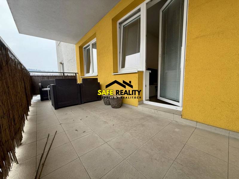 Balkon 2-pokojového bytu v Žilině s dlážděnou podlahou a zahradním nábytkem.