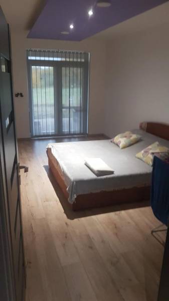 Ložnice v rodinném domě s postelí a podlahou s dřevěným dekorem.