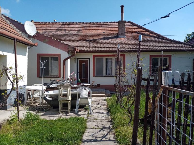 Rodinný dům v Nových Zámcích s terasou, plastovými židlemi a satelitní anténou.