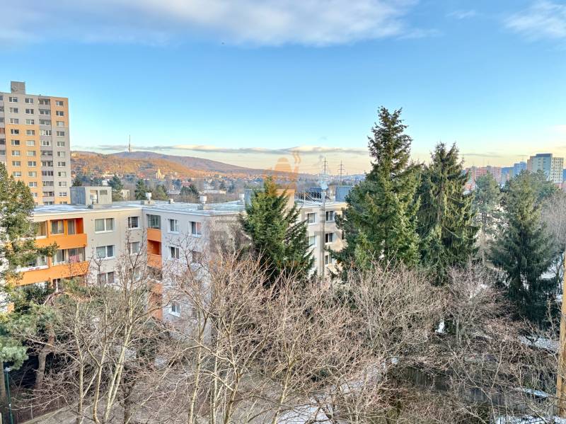 Zobrazená je panoráma bytovek a stromů na Drobného ulici v Bratislavě - Dúbravce.