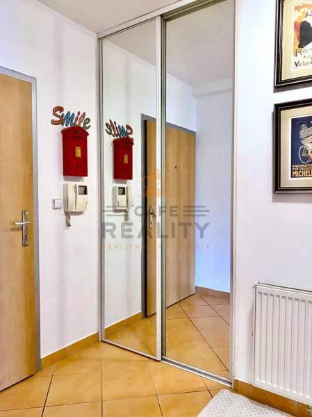 Chodba s dlažbou, vestavěnou skříní a poštovní schránkou v 2-pokojovém bytě.