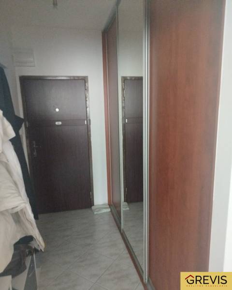 Chodba s dlažbou a velkým zrcadlem v garsonce.